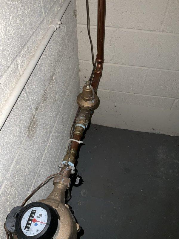 Performed comprehensive plumbing inspection for new homeowner, with primary focus on water heater system and associated plumbing infrastructure. Inspected main water supply lines, shut-off valves, water meter, and distribution piping throughout mechanical space. Evaluated condition of existing gate valves with identification tags, copper supply lines with foam insulation, and brass fittings showing age-related patina and oxidation. Documented current state of plumbing system including water heater connections, supply and return lines, and shut-off valve functionality for homeowner's records and future maintenance planning.