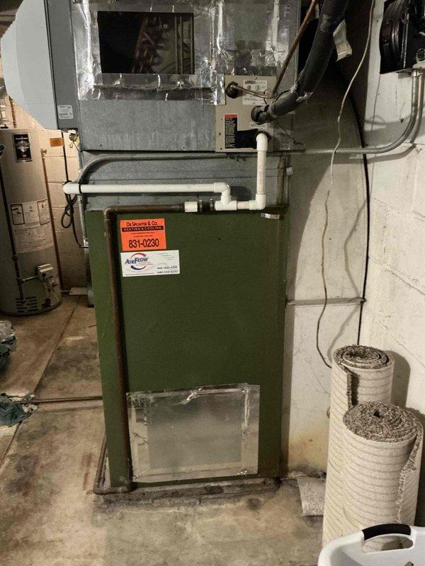 Conducted on-site HVAC estimate for furnace replacement in residential basement mechanical room. Evaluated existing green-colored furnace unit with PVC venting system and assessed current installation configuration including ductwork connections, electrical service, and clearance requirements. Documented equipment specifications, photographed existing system layout, and provided replacement options for aging furnace unit.