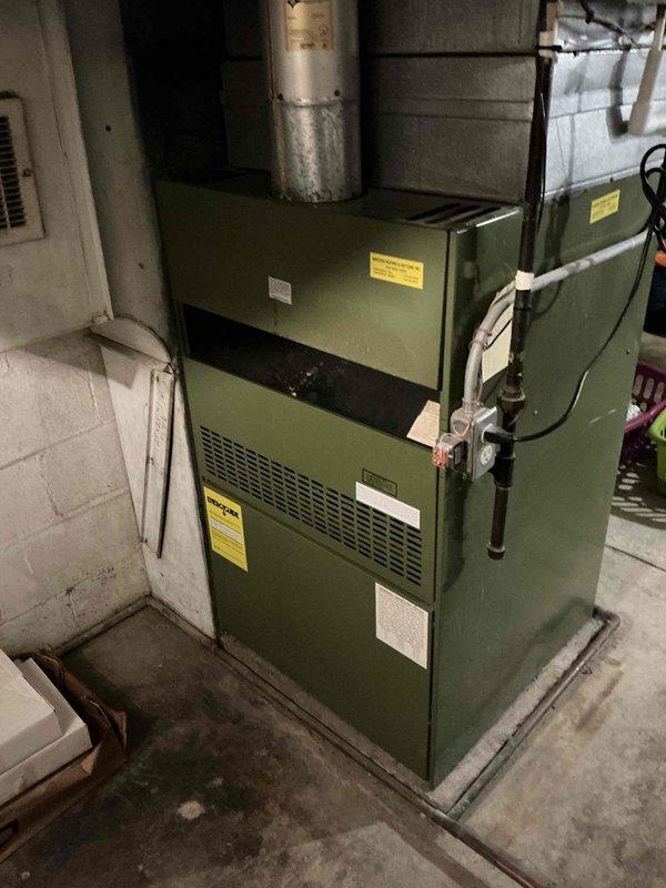 Conducted on-site HVAC estimate for furnace replacement in residential basement mechanical room. Evaluated existing green-colored furnace unit with PVC venting system and assessed current installation configuration including ductwork connections, electrical service, and clearance requirements. Documented equipment specifications, photographed existing system layout, and provided replacement options for aging furnace unit.