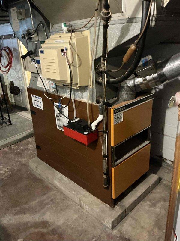 Completed estimate for replacement of 60+ year old furnace that was previously red-flagged and shut down due to safety concerns. Customer requested permits be included with the replacement proposal. Documentation and photos taken of existing equipment configuration, including outdated heating unit, ductwork system, water heater, and associated mechanical components in basement utility area.