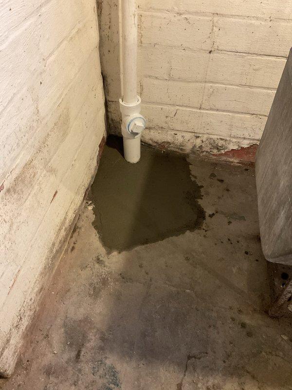 Completed kitchen sink drain replacement at residential property. Two-person crew successfully removed existing deteriorated drain assembly and installed new PVC drainage system. Work included addressing significant floor deterioration and water accumulation issues discovered at the base of the existing vertical drain pipe in the basement utility area. Cleared debris and standing water from affected concrete floor section, ensuring proper drainage flow and structural integrity of new installation. All components installed to code specifications with secure connections and proper sealing to prevent future moisture infiltration.