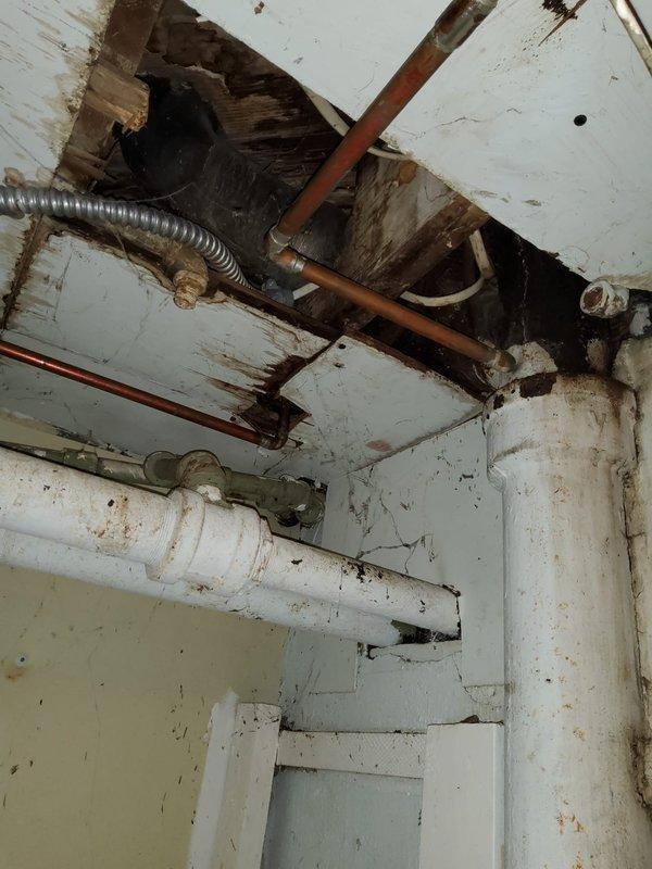 Responded to service call for broken toilet handle replacement. Upon arrival, conducted comprehensive plumbing assessment of property as requested. Documented extensive water damage and deterioration to basement ceiling area, including significant rust staining on white PVC and copper piping, compromised ceiling material with exposed structural beams, and evidence of long-term moisture intrusion affecting multiple pipe runs and cleanout fittings. Photographed conditions for record and recommended further evaluation of water damage source and structural concerns.