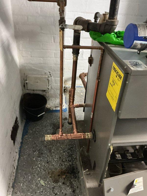 Replaced compromised copper piping components including a 1-1/2" elbow, tee fitting, short nipple, and small nipple on the tee side connection. All damaged sections were removed and new fittings were installed to restore proper system integrity and prevent leaks in the heating system piping network.