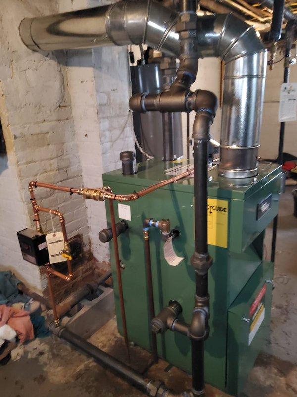 Completed full installation of New Yorker model CGS50C steam gas boiler in basement mechanical room. Installation included new automatic water feeder with digital display, backflow preventer, digital programmable thermostat, and complete flue pipe assembly to chimney. All near boiler piping modifications were performed including copper supply lines, valve installations, and proper venting connections to ensure safe and efficient operation of the new steam heating system.