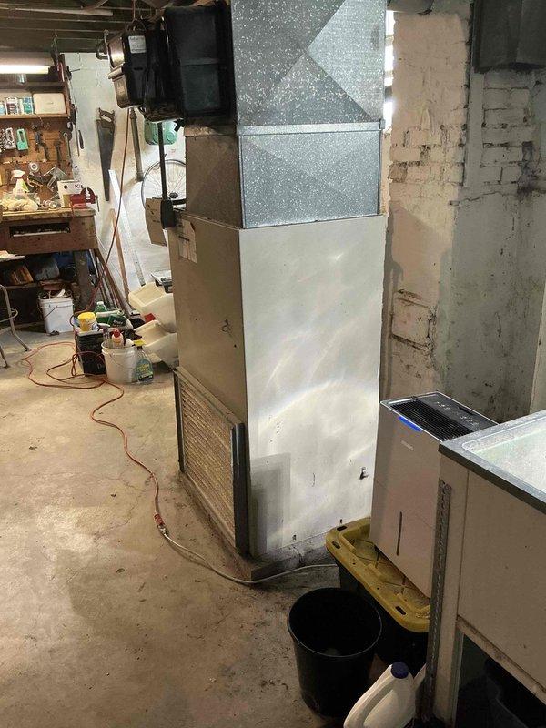 Responded to no-heat call on 35-year-old furnace and identified cracked heat exchanger requiring immediate replacement for safety. Provided customer with equipment replacement estimate and documented existing HVAC system configuration including furnace, ductwork, and surrounding mechanical equipment in basement utility area.