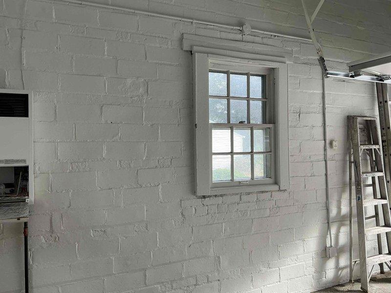 Completed estimate for garage heater replacement in white brick interior space. Assessed existing through-wall heating unit and provided multiple equipment options for upgraded heating system. Documented current installation configuration and discussed various heater models suitable for the space requirements and customer preferences.