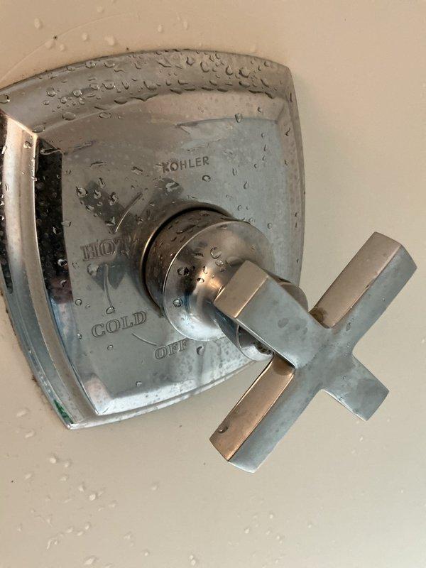 Responded to service call for leaky faucet repair and plumbing inspection. Upon arrival, inspected under-sink plumbing installation including chrome P-trap drain assembly, shut-off valves, and supply line connections. Examined Kohler shower valve fixture with cross-style handle for potential leaks and proper operation. Identified moisture presence on shower valve and surrounding wall surface. Verified all plumbing connections, checked for loose fittings at threaded connections and wall penetration points, and assessed condition of existing sealant. Completed visual inspection of accessible plumbing components and documented findings with photographic evidence for service records.