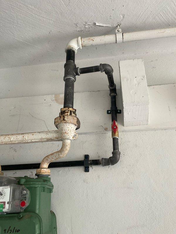 Installed new 1/2" gas line for garage heater application. Work included routing black iron pipe with appropriate fittings: one 1" x 1/2" reducing tee, three 90-degree elbows, two 45-degree elbows, one union for serviceability, one tee, and one cap. Line was properly secured to wall structure with mounting brackets and pressure tested to ensure leak-free operation and code compliance.