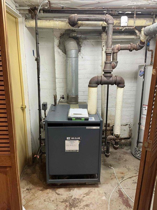 Conducted on-site evaluation of residential steam boiler system for replacement estimate. Assessed existing 30+ year old Weil-McLain boiler unit, associated piping infrastructure including supply and return lines, and water heater configuration in basement mechanical room. Documented equipment condition, photographed current installation showing aged piping with visible corrosion on metal fittings, and reviewed system layout to provide comprehensive replacement recommendations with financing options.