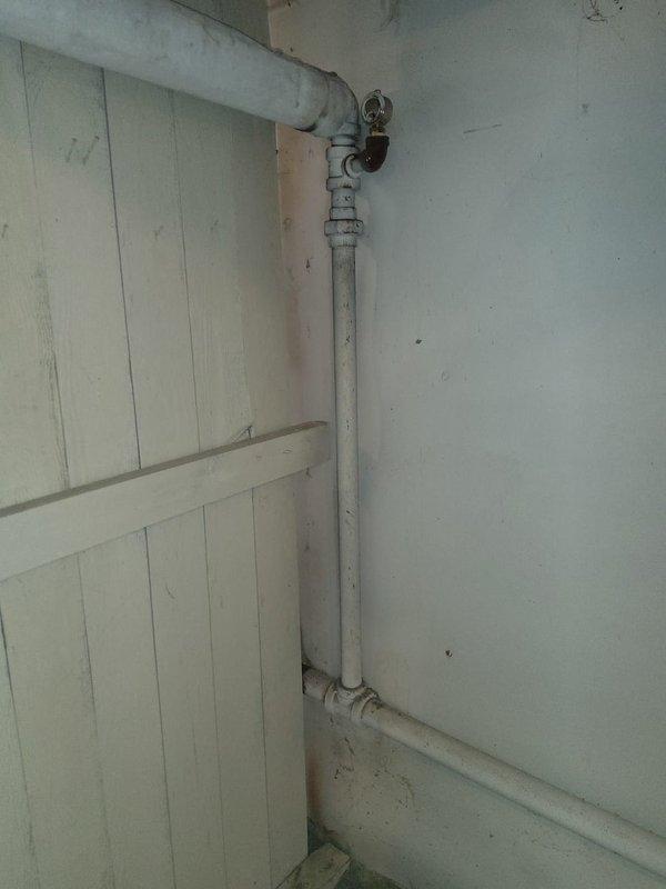 Responded to service call for boiler system with reported pinhole leak in supply piping. Upon inspection, identified small leak at pipe connection point leading to boiler unit. Documented existing conditions of gas piping system and surrounding utility area, noting multiple fittings and connections along vertical pipe run requiring monitoring for potential future service needs.