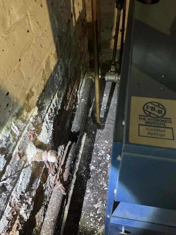 Conducted boiler replacement estimate for existing Dunkirk PVSV5 unit showing significant age and deterioration. Site assessment revealed severe moisture infiltration issues with extensive water damage to surrounding concrete walls, heavy frost and ice accumulation on copper piping, and compromised mechanical room conditions requiring attention during replacement installation.