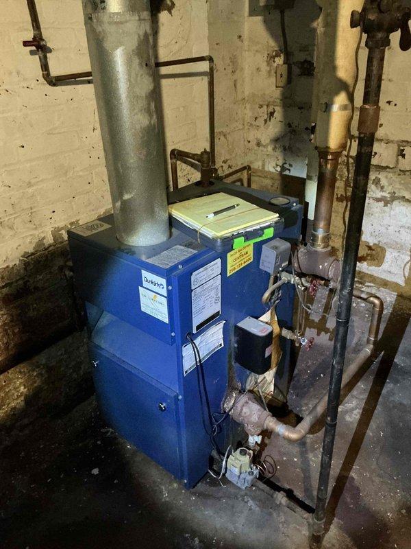 Conducted boiler replacement estimate for existing Dunkirk PVSV5 unit showing significant age and deterioration. Site assessment revealed severe moisture infiltration issues with extensive water damage to surrounding concrete walls, heavy frost and ice accumulation on copper piping, and compromised mechanical room conditions requiring attention during replacement installation.