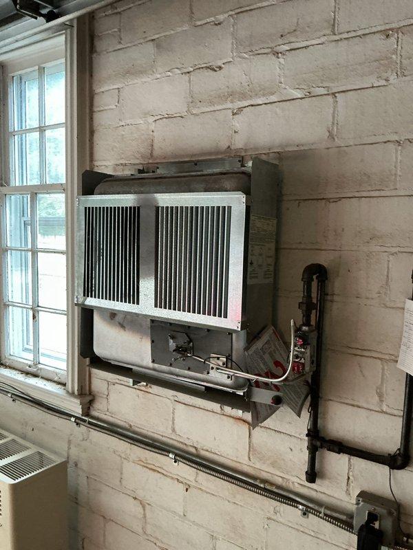 Completed comprehensive heating maintenance on three systems including boiler, furnace, and garage unit. Performed standard inspections, filter changes, and safety checks on all equipment. Documented equipment conditions with photos showing aging HVAC components including deteriorated paint on ductwork assembly and through-wall heating unit with visible wear on metal casing and electrical connections.
