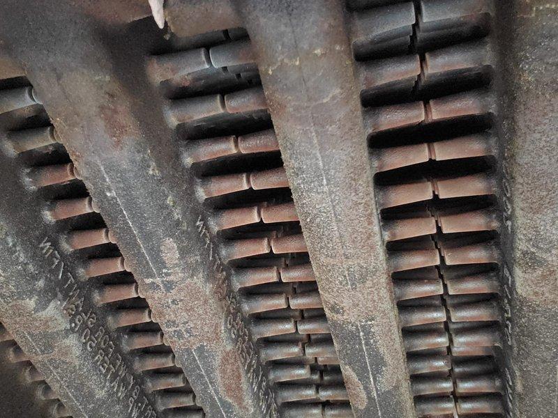 Completed scheduled boiler maintenance under home plan agreement. Thoroughly inspected heat exchanger components, including primary heat exchanger fins and secondary heat exchanger drum assembly. Both heat exchangers showed significant rust accumulation and corrosion on metal surfaces, indicating extended service life and exposure to moisture during normal operation. Documented current condition of copper-alloy fins and cylindrical pin-type heat exchanger with photographic evidence for maintenance records. All components remain functional despite visible oxidation and patina buildup typical of aging boiler systems.