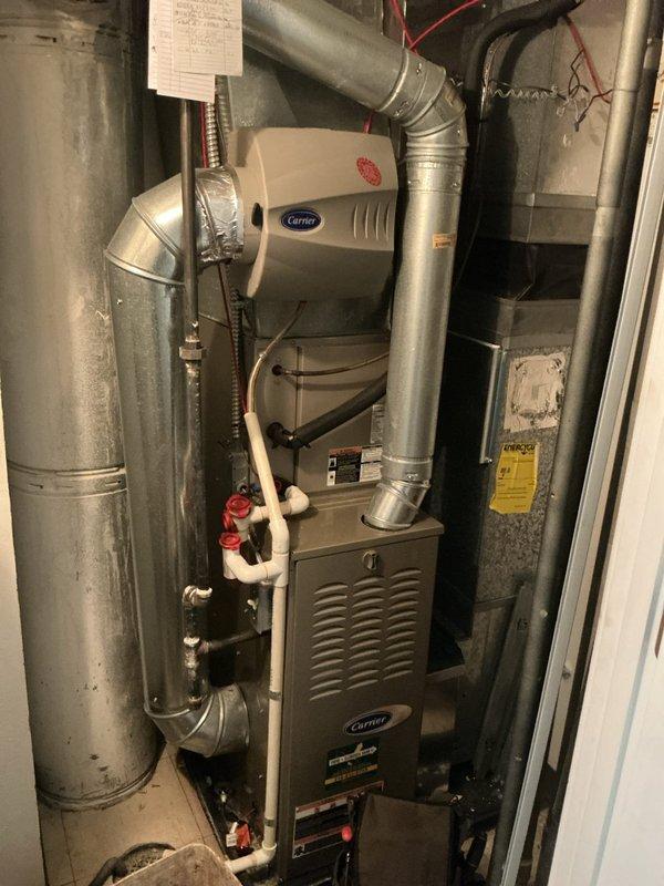 Performed comprehensive heating system tune-up on Carrier furnace located in basement. Conducted thorough inspection of furnace cabinet, heat exchanger, and burner assembly. Verified proper operation of integrated Carrier humidifier system with visual inspection of water supply lines and shut-off valves. Tested combustion efficiency using digital analyzer, recording oxygen levels at 16.5%, carbon monoxide readings, carbon dioxide levels, and temperature differentials with supply air at 281°F and return air at 75°F. All combustion parameters within manufacturer specifications. Inspected ductwork connections and metallic flex conduit for secure fastening and proper sealing. Verified electrical connections and wiring integrity throughout system. Examined PVC drainage lines and confirmed proper valve operation. Provided guidance on ecobee thermostat system operation and programming as requested. System operating efficiently with no deficiencies noted. All safety controls functioning proper