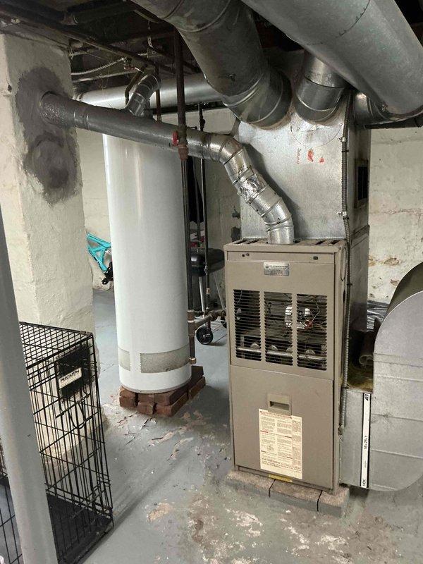 Conducted on-site evaluation of existing HVAC system in residential basement mechanical room for furnace replacement estimate. Assessed current beige/tan furnace unit and surrounding infrastructure, including ductwork configuration, water heater proximity, clearance requirements, and electrical connections. Documented equipment specifications, measured available space for new unit installation, photographed existing system layout and mechanical room conditions to prepare comprehensive replacement proposal.