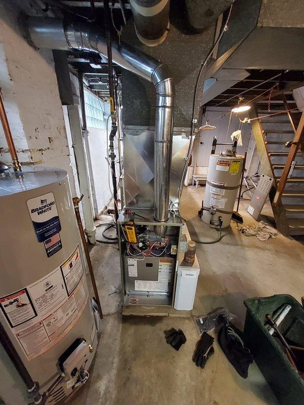 Completed installation of new Bryant 80% efficiency gas furnace with two-stage heating and high-efficiency variable speed blower motor in basement mechanical room. Installed new Aprilaire air cleaner with high-efficiency air filter and removed existing humidifier, patching associated ductwork to maintain system integrity. Replaced water heating system with new Bradford White 40-gallon hot water tank including new expansion tank, connecting all copper supply lines and ensuring proper venting. Reused existing thermostat for system control. All equipment installed per manufacturer specifications, electrical connections completed, gas lines tested for leaks, and condensate drainage verified. System tested and confirmed operational with proper airflow, combustion efficiency, and safety controls functioning as designed.