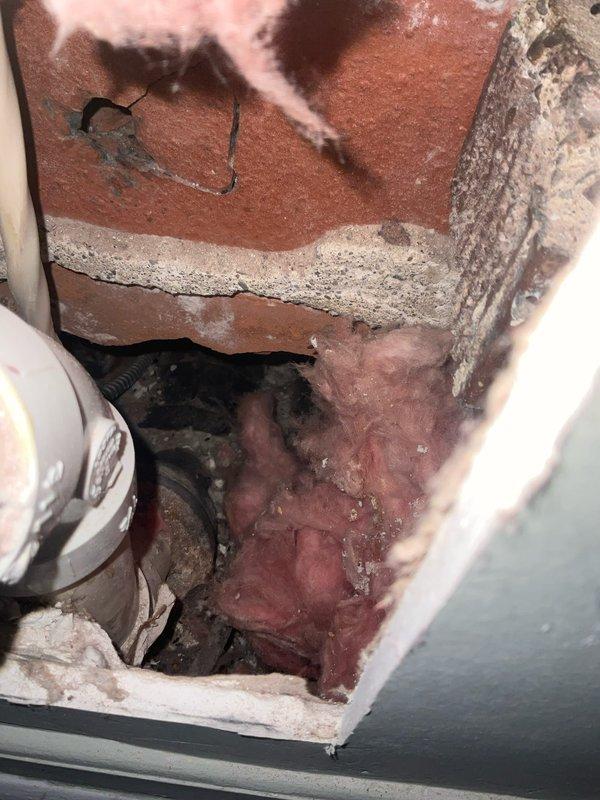 Performed investigative leak detection work requiring selective demolition of interior walls and ceiling materials. Two-person crew opened multiple access points to trace active water intrusion through building envelope. Exposed interior wall cavities revealed compromised areas around plumbing penetrations, including deteriorated mortar joints in brick masonry and gaps in structural materials where PVC and metal piping passed through. Located source of leak at pipe penetration points where inadequate sealing and aged building materials allowed water infiltration. Documented existing conditions including damaged insulation, exposed wiring, and deteriorated concrete surfaces. Total duration of investigative work was two hours with photographic documentation completed for subsequent repair planning.