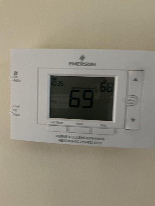 Completed routine furnace maintenance on 10-year-old residential heating system located in basement. Performed comprehensive inspection of furnace unit and associated HVAC components, verified proper operation of Emerson digital thermostat displaying current temperature settings, and ensured all safety labels and specifications were visible and intact. System tested and confirmed operational with all components functioning within normal parameters.