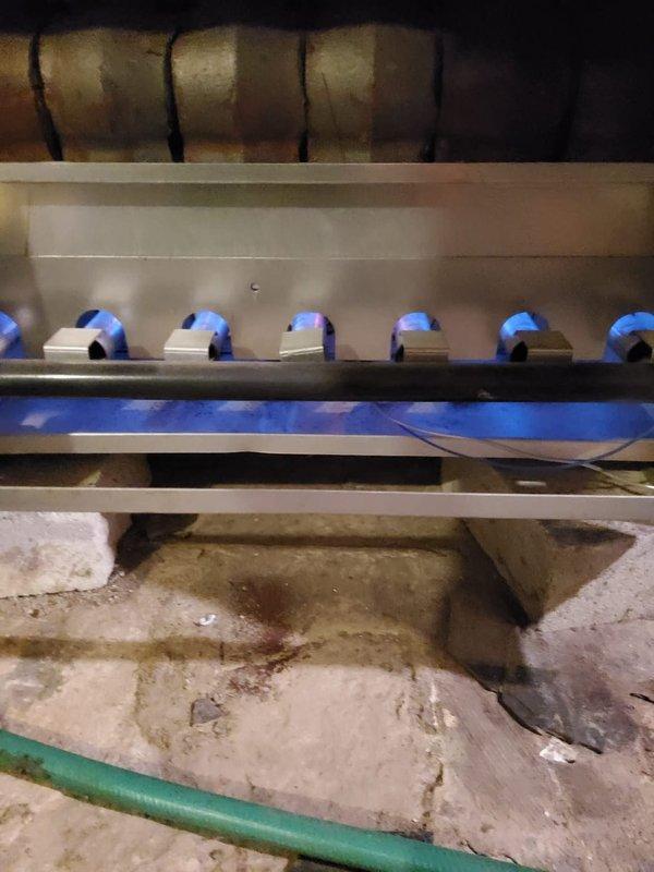 Completed preventive maintenance on gas-fired boiler system. Inspected burner assembly and confirmed proper ignition with all burners firing with clean blue flames. Verified heat exchanger condition and checked all system components for safe operation.