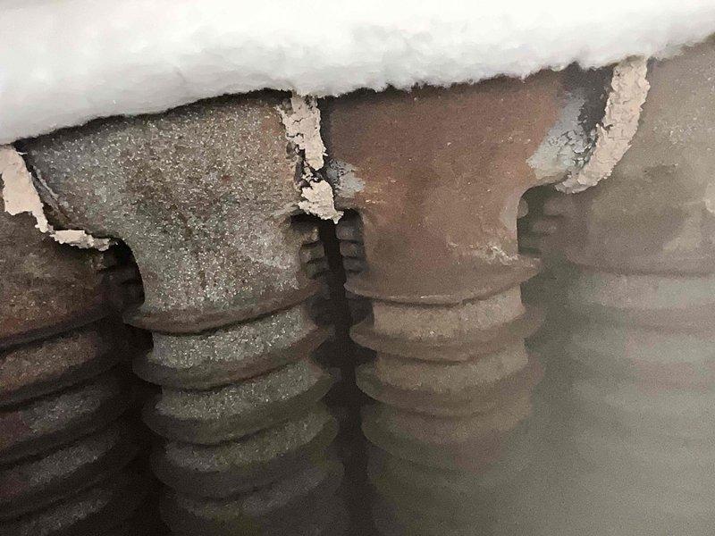 Performed scheduled maintenance on a 2-year-old steam boiler system. Upon inspection, discovered significant water damage throughout the mechanical room, including heavily stained concrete flooring and deteriorated materials indicating ongoing moisture infiltration issues. Examined copper piping system showing age-related corrosion with visible green patina on surfaces, along with associated valves and fittings. Assessed damaged insulation material in overhead areas with torn sections and deterioration requiring attention. Documented conditions of HVAC equipment and surrounding infrastructure affected by prolonged water exposure. Recommended addressing moisture source and water intrusion problems to prevent further deterioration of mechanical systems and building components.