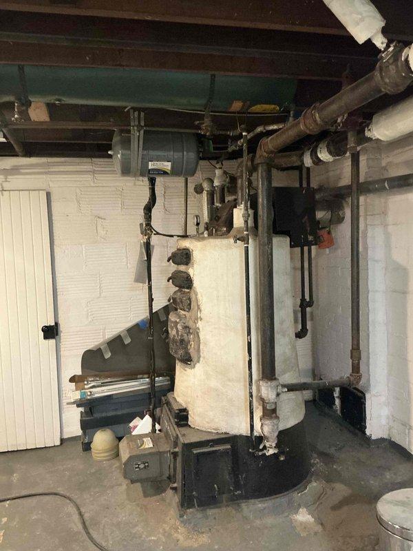 Conducted comprehensive boiler replacement estimate for century-old heating system in basement mechanical room. Evaluated existing boiler with extensive insulation deterioration, assessed removal requirements and clearances, documented current piping configuration including expansion tank and distribution lines, and provided multiple equipment options for complete system replacement to meet modern efficiency and safety standards.