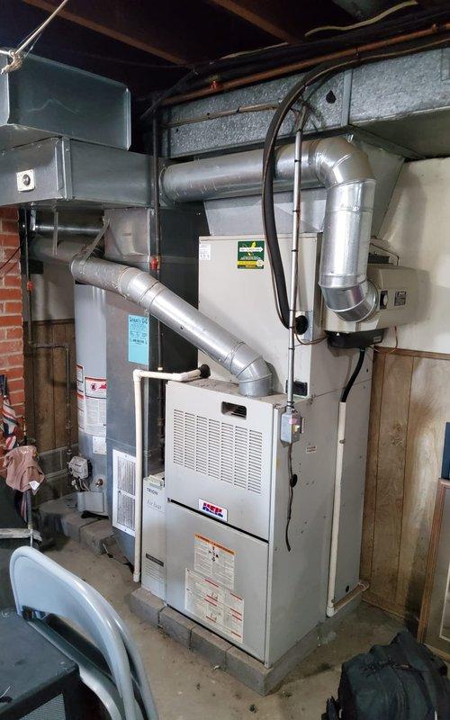 Performed comprehensive tune-up and maintenance on 25+ year old furnace system in residential basement installation. Conducted thorough inspection of blower motor assembly, ductwork connections, and all mechanical components. Evaluated thermostat operation and temperature accuracy concerns reported by homeowner, checking calibration and system cycling. Inspected burner assembly, heat exchanger, gas connections, and electrical wiring for safety and proper operation. Cleaned blower compartment, checked belt tension and motor bearings, and verified proper airflow through extensive metallic ductwork system. Tested all safety controls and limit switches to ensure proper function. Given the advanced age of the unit, documented current operating condition and recommended monitoring for potential future replacement considerations.