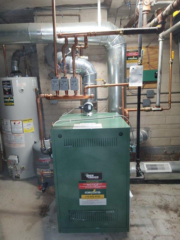Completed full boiler replacement in residential basement, installing New Yorker model CG70 cast iron hot water boiler rated at 210,000 BTUs. Installation included new Amtrol expansion tank, pressure reducing valve with backflow preventer, automatic air vent, and circulator pump. Performed all near boiler piping modifications using copper pipe and brass fittings, and installed new flue pipe connection to existing chimney. Reused existing thermostats, zone valves, and zone panel from previous system. System tested and operational with limited lifetime warranty on heat exchanger, 5-year parts, and 5-year labor coverage.