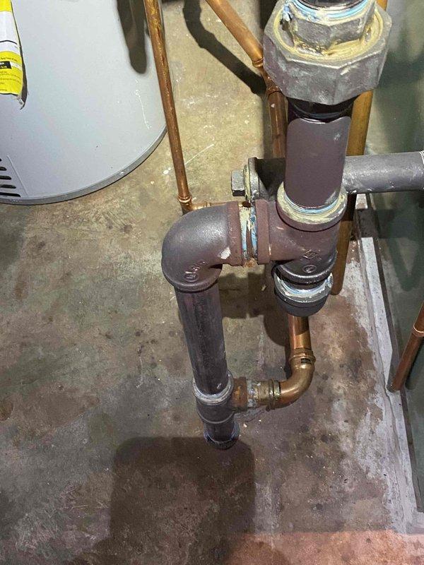 Responded to service call for 3-year-old steam boiler system with reported pipe corrosion. Upon inspection, identified severe corrosion on horizontal steam pipe with extensive rust buildup, pitting, and metal deterioration requiring immediate repair. Documented existing plumbing configuration including copper risers, brass fittings, and connection points to facilitate proper repair planning and parts procurement.