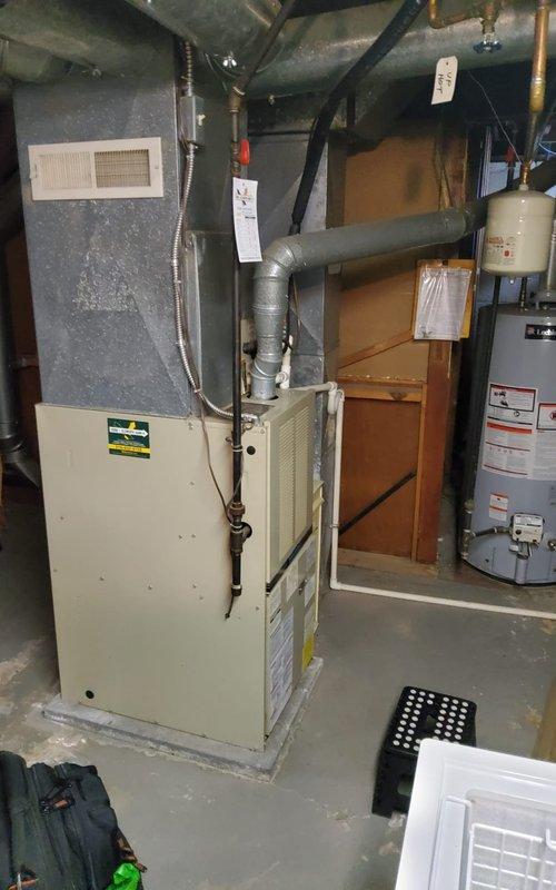 Responded to service call for 10-year-old furnace reported not heating properly. Performed comprehensive clean and check maintenance service on gas furnace system. Inspected combustion chamber and confirmed all four burners igniting properly with clean blue flames. Verified gas manifold connections secure and operating within specifications. Checked blower assembly, heat exchanger, and all safety controls for proper operation. Cleaned burner assembly and combustion area. Inspected venting system and confirmed proper draft. Tested thermostat operation and system cycling. Documented equipment condition with photos showing active burner operation and overall unit condition in basement installation. Unit operational and heating effectively upon service completion.