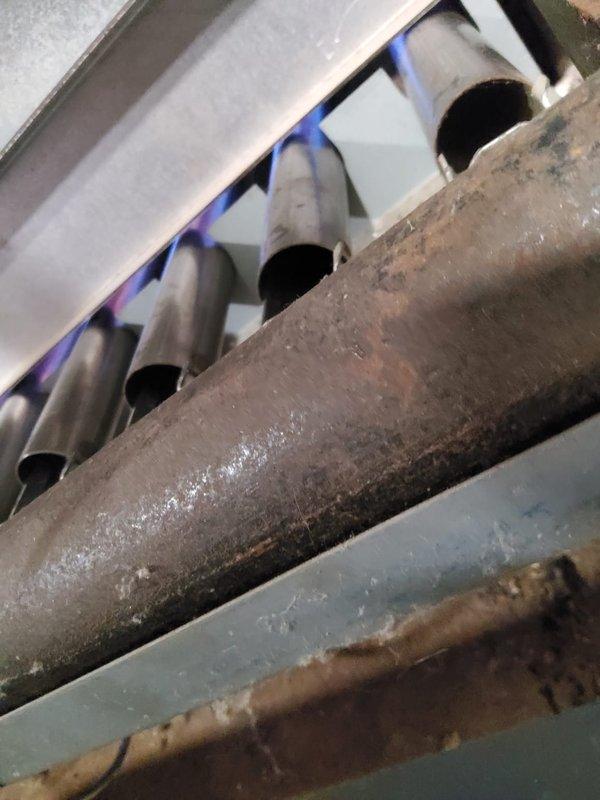 Performed maintenance on 24-year-old steam boiler system. Addressed stuck valve issue and inspected heat exchanger components, which showed significant frost and ice accumulation on evaporator coils indicating potential airflow restriction or refrigerant issues. Examined burner tubes and piping, noting corrosion and rust on lower pipe sections requiring monitoring for future service needs.