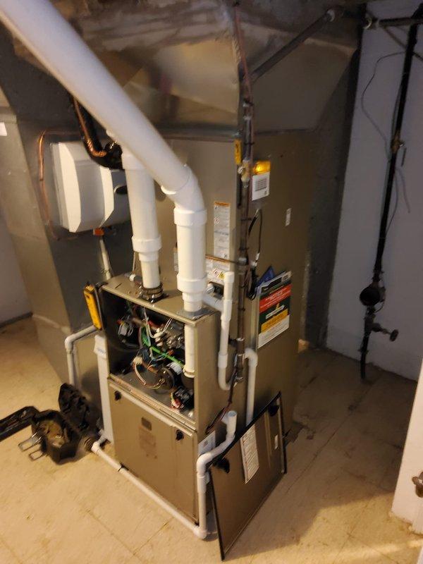 Completed full HVAC system replacement including furnace, evaporator coil, air conditioning condenser unit, Ecobee smart thermostat, and 700CFM media air cleaner. Removed existing equipment and installed new high-efficiency furnace in basement utility area with proper venting configuration using white PVC intake and exhaust pipes. Mounted new evaporator coil on furnace plenum and connected refrigerant lines to outdoor condensing unit. Installed Ecobee thermostat with updated wiring and configured system settings for optimal performance. Integrated 700CFM media air cleaner into ductwork for enhanced indoor air quality. Ran all necessary electrical connections including new conduit and wiring to code specifications. Verified system operation with dual port manometer readings showing proper static pressure at 0.347 inches water column. Tested all safety controls, airflow, and thermostat functionality to ensure complete system integration and performance.