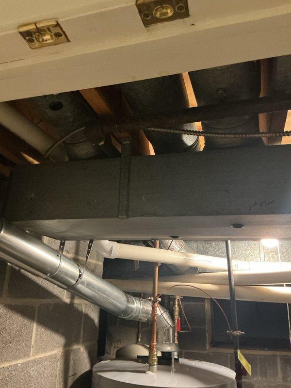 Completed HVAC system replacement in residential property, installing new Bryant furnace unit to address inadequate heating performance in upper level zones. Previous system was undersized for the home's heating demands, resulting in insufficient temperature control on the second floor. Installed appropriately sized replacement unit with new refrigerant lines, proper insulation wrapping on copper tubing, and integrated ductwork connections to existing infrastructure in basement mechanical room. System properly mounted and connected to structural supports with all refrigerant lines secured and insulated to prevent heat loss and condensation issues.