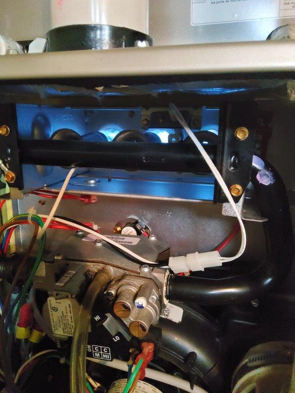 Performed a heating system maintenance inspection on a gas furnace, verifying burner ignition with a clean, stable blue flame and inspecting the gas valve, manifold, and wiring for damage, with no visible rust, frost, or breakage. Conducted combustion analysis with a Testo 310, recording O₂ at 8.9% and CO at 49 ppm, and the system remains operational with combustion readings documented for ongoing monitoring.