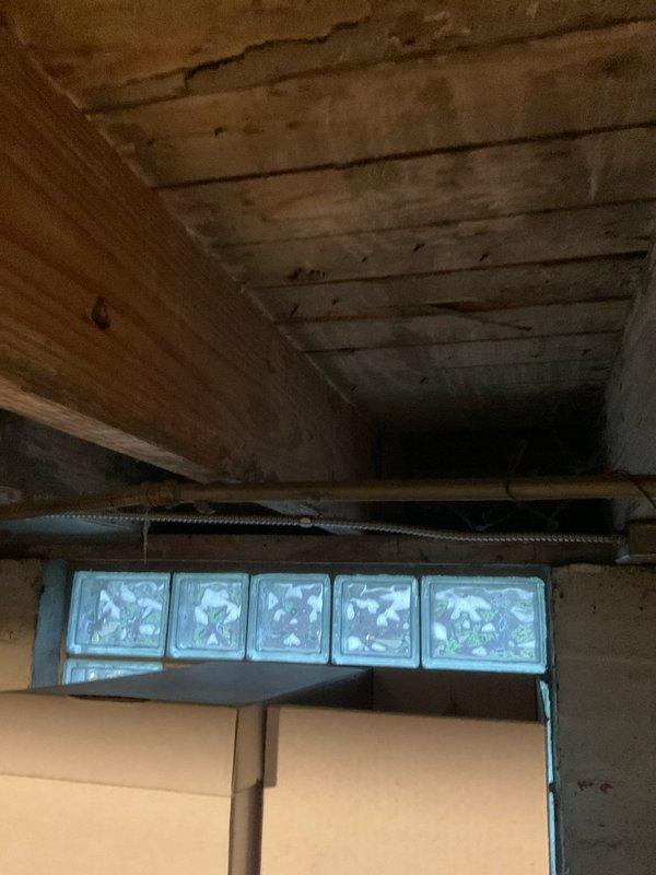 Performed an on-site evaluation for a tankless water heater conversion, inspecting the existing tank-style unit with insulated copper supply and return lines and a galvanized flue connected to a larger vent duct. Assessed basement conditions, including overhead pipe routing, available wall space, and ventilation and venting options to determine installation requirements for a tankless unit. Documented all conditions with photos to support the recommended scope of work.