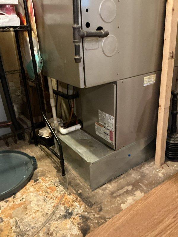 Responded to a no-heat call and inspected the gas furnace/air handler installation, including the refrigerant line set, condensate drain piping with condensate pump, and surrounding utility space. Evaluated the unit's condition and provided a furnace replacement estimate.