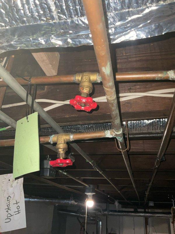 Roughed in a new tub spout supply line for the second-floor bathroom, tying into the existing copper supply piping in the basement ceiling. Installed and secured the new copper run and fittings, with isolation valves accessible at the branch for future service. Verified the connections for proper routing and support, and identified the existing "Upstairs Hot" line to ensure the new tie-in was made on the correct supply.