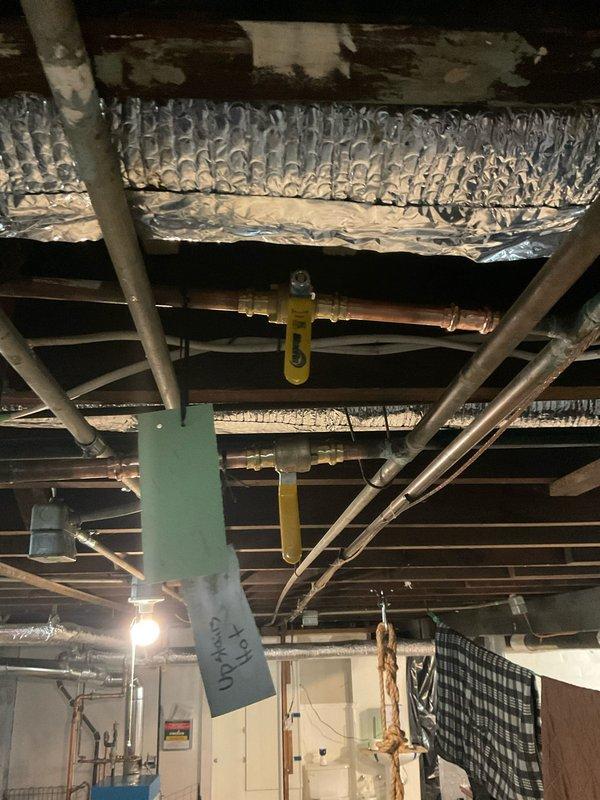 Roughed in a new tub spout supply line for the second-floor bathroom, tying into the existing copper supply piping in the basement ceiling. Installed and secured the new copper run and fittings, with isolation valves accessible at the branch for future service. Verified the connections for proper routing and support, and identified the existing "Upstairs Hot" line to ensure the new tie-in was made on the correct supply.