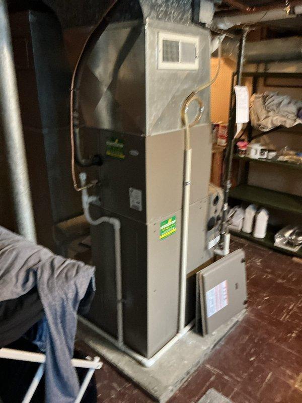 Performed an on-site replacement estimate for an existing gas-fired condensing furnace and air handler installation in the basement utility area. Inspected the unit with the access panel removed, documenting the burner compartment, wiring, PVC vent and condensate lines, black iron gas supply, copper refrigerant lines, and supply plenum/ductwork configuration. Equipment showed no visible frost, ice, rust, or damage, and unit data and existing layout were recorded to determine replacement scope and sizing.