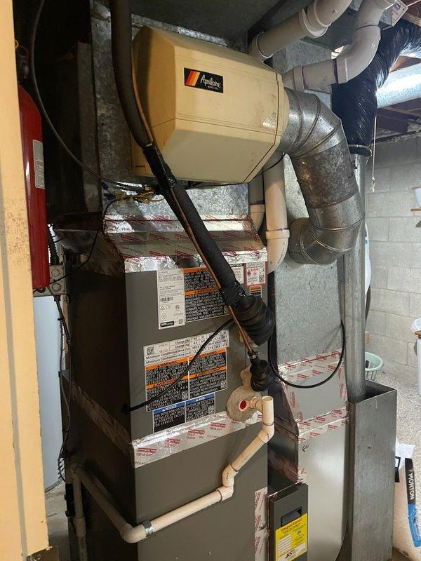 Responded to service call for humidifier leak issue. Inspection revealed the humidifier drain hose was not connected during previous furnace installation. Technician reconnected the drain hose to the Aprilaire humidifier unit, resolving the water leakage problem.