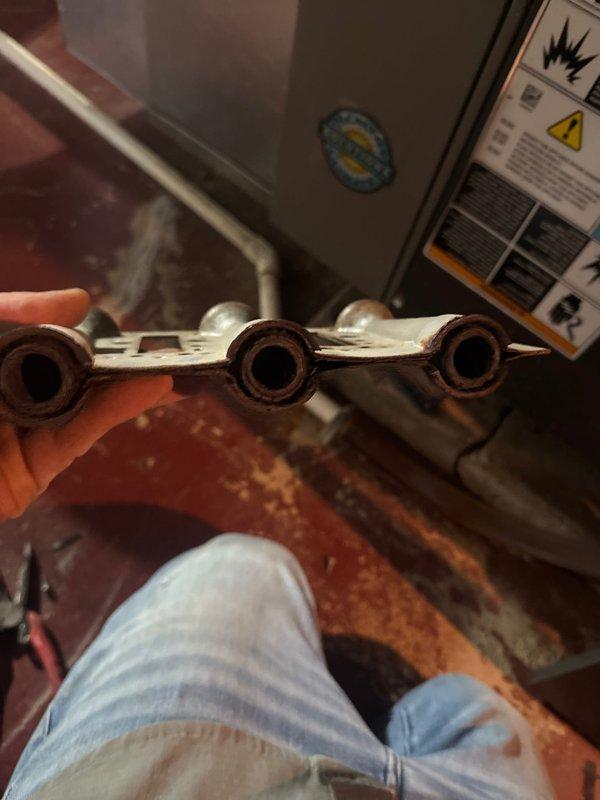 Arrived on site for scheduled installation of new burner assembly and thermostat in aging HVAC system. Removed existing corroded burner assembly which showed significant oxidation on burner tubes and perforated base plate. Successfully completed installation of replacement burner assembly and new thermostat as specified. System functioning properly after service.