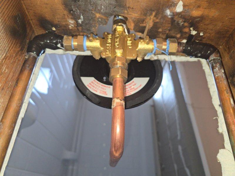 Responded to service call for a shower valve leak. Diagnosed bad solder joint on 1/2" copper 90 fitting at hot water inlet of shower valve. Removed compromised fittings and pipe, then installed new components. Tested system after repair with water turned on, confirming successful resolution of the leak with proper function restored.