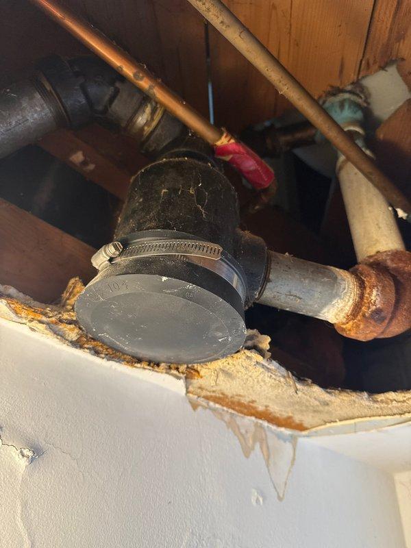 Responded to service call for tub leak. Diagnosed issue as a leaking drum trap with visible corrosion and water damage to surrounding materials. Determined replacement of drum trap and overflow assembly necessary; scheduled follow-up appointment with additional technician pending customer financing approval.
