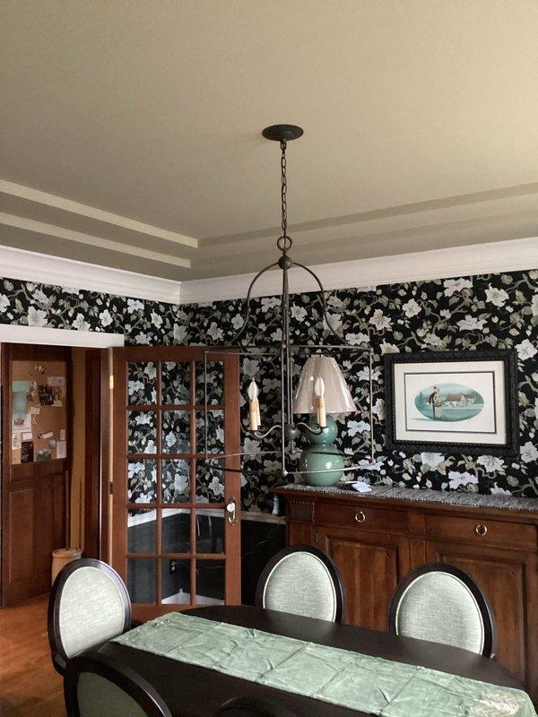 Successfully removed existing chandelier in dining room and installed new cage-style decorative fixture with multiple candle-shaped bulbs. Ensured proper wiring connections and secure mounting of the new light fixture. Confirmed proper operation before completing service.