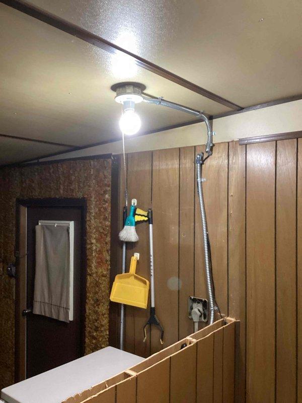 Arrived for scheduled thermostat relocation and washer outlet installation according to estimate. Inspected existing electrical fixtures including ceiling-mounted light with flexible metal conduit in the utility area. Successfully completed installation work as specified, ensuring all connections were secure and properly functioning.