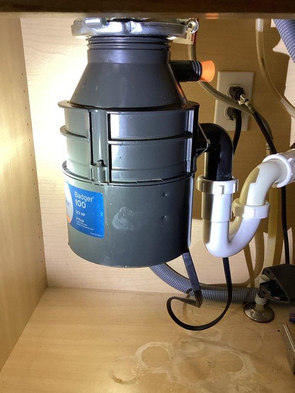 Resolved garbage disposal leak by reinstalling loose mounting ring and replacing missing plastic feral on drain assembly compression nut. Unit was tested after repair and confirmed to be functioning properly with no leaks.