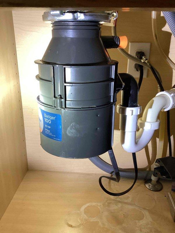 Resolved garbage disposal leak by reinstalling loose mounting ring and replacing missing plastic feral on drain assembly compression nut. Unit was tested after repair and confirmed to be functioning properly with no leaks.