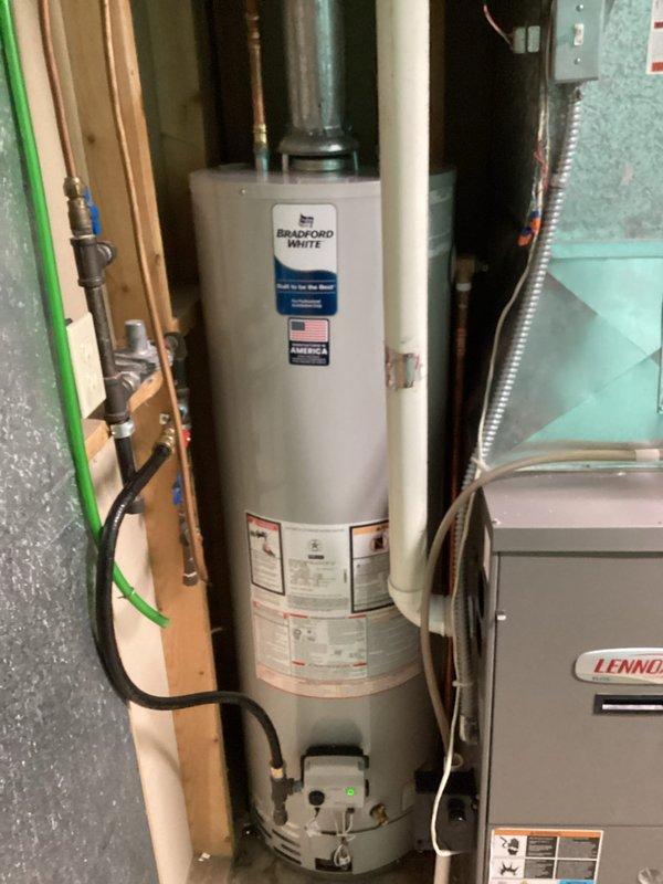Successfully installed a new Bradford White 40-gallon water heater according to specifications. Completed all necessary plumbing connections, including proper venting and piping, ensuring the unit was operational in the utility room alongside the existing Lennox HVAC system.