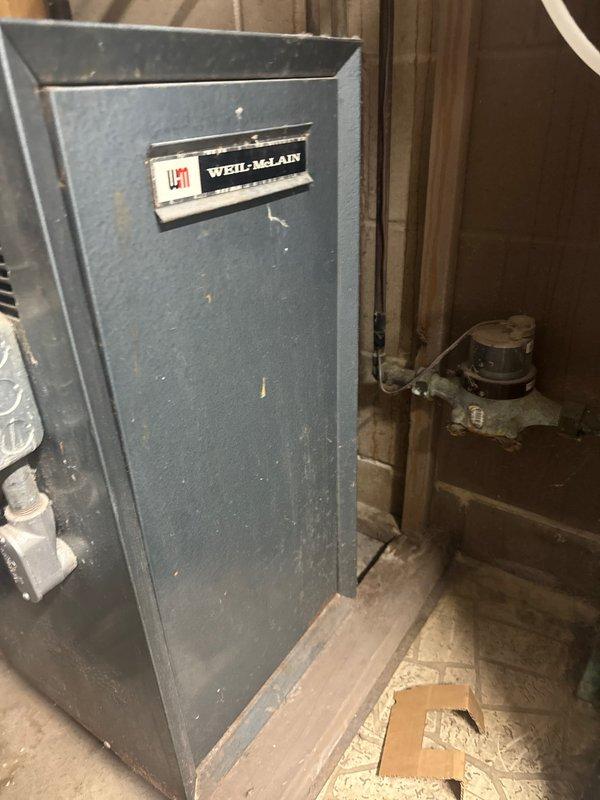 Diagnosed and replaced faulty zone valve actuator on Weil-McLain boiler system that was causing downstairs zone to overheat. Issue was confirmed during arrival at 12:04, with zone valve not properly actuating to control heating distribution.