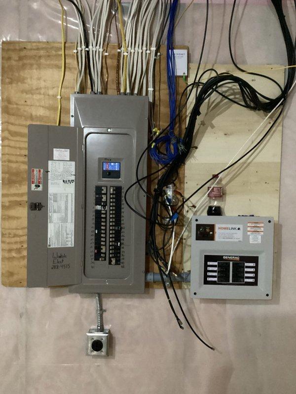 Completed installation of a Generac HomeLink transfer switch system, including final wiring connections between the main electrical panel and transfer switch. All circuit breakers were properly configured, and the system was successfully installed for battery backup functionality.